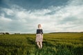 Young girl in a green field. Stylish girl. Green grass and blue sky. Emotional woman. plener. Travel. trip.