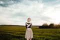 Young girl in a green field. Stylish girl. Green grass and blue sky. Emotional woman. plener. Travel. trip.