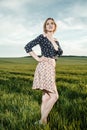 Young girl in a green field. Stylish girl. Green grass and blue sky. Emotional woman. plener. Travel. trip.