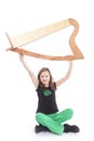 Young girl in green pants lifts harp in studio