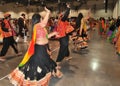 A young girl and group of people are enjoying Hindu festival of Navratri Garba wearing traditional consume.