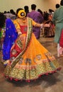 A young girl and group of people are enjoying Hindu festival of Navratri Garba wearing traditional consume.