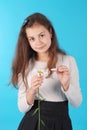 Young girl guesses on a chamomile flower. Young girl tears off petals of daisy
