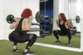 Young girl in the gym doing squat