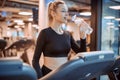 Young girl at the gym trainer holding a bottle of water. Portrait of beautiful young fit woman drinking water during Royalty Free Stock Photo