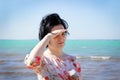 A young girl with hair stands on the beach by the sea and looks into the distance Royalty Free Stock Photo