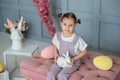 Young Girl with hairstyle buns holding toy rabbit in his hands. Closeup portrait Beautiful little Girl playing with easter bunny.