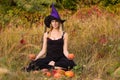 Young girl in witch costume training lotus pose