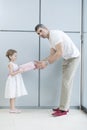 Young girl handing present to her father