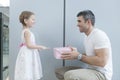 Young girl handing present to her father