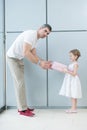 Young girl handing present to her father