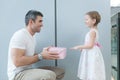 Young girl handing present to her father