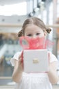 Young girl handing present towards camera