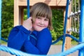 Young girl hanging in web of blue ropes