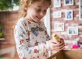 Young girl happy holding a cute fluffy yellow new baby chick adorable just hatched at home in incubator she is excited and chicken Royalty Free Stock Photo