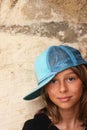 Young girl with hat with back against the wall