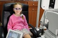 Young girl is having eye exam performed by optician, optometrist or eye doctor