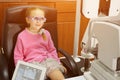 Young girl is having eye exam performed by optician, optometrist or eye doctor