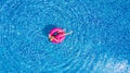 Young girl having fun and laughing and having fun in the pool on an inflatable pink flamingo in a bathing suit in summer from abov Royalty Free Stock Photo