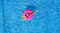 Young girl having fun and laughing and having fun in the pool on an inflatable pink flamingo in a bathing suit in summer from abov Royalty Free Stock Photo