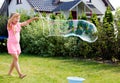 Girl making soap bubbles in home garden Royalty Free Stock Photo