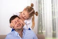 A young girl  is having fun playing with her dad, closing his eyes so that he can guess who it is Royalty Free Stock Photo