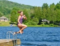 Young girl having summer fun jumping into lake of the dock Royalty Free Stock Photo