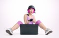 Young girl in the helmet with joystick sits on the floor and playing game on a laptop