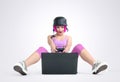 Young girl in the helmet with joystick sits on the floor and playing game on a laptop Royalty Free Stock Photo