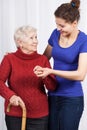 Young girl helping senior woman