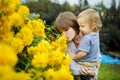 Young girl and her brother admiring bright yellow flowers of rudbeckia, commonly known as coneflowers or black eyed susans, in a