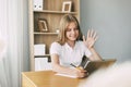 A young girl and her friends are preparing for lessons online using a tablet and video communication. Online training Royalty Free Stock Photo