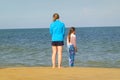 Young girl and her mother looking out to sea at Bethany Beach, DE