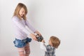 Young girl and her small brother fighting for the drone remote c