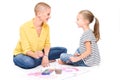 Young girl and her therapist in child occupational therapy session painting with watercolors. Child therapy concept.