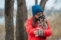 Young girl in her warm clothing. Teenage girl in a hat. Chihuahua dog with girl. Girl kissing a dog