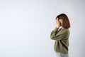 Young girl hiding face in hands on white background. Space for text Royalty Free Stock Photo