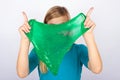 Young girl hiding her face behind a green slime Royalty Free Stock Photo