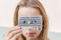 A young girl holding an audiotape