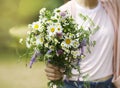 A young girl holding a bouquet of wildflowers in hands Royalty Free Stock Photo