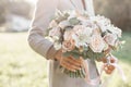 Young girl holding a beautiful spring bouquet. flower arrangement with garden roses. Color light pink. Bright dawn or