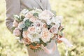 Young girl holding a beautiful spring bouquet. flower arrangement with garden roses. Color light pink. Bright dawn or