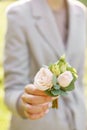 Boutonniere. Young girl holding a beautiful spring Flowers. flower arrangement with roses. Color light pink. Bright dawn