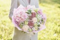 Young girl holding a beautiful spring bouquet. flower arrangement with hydrangea and garden roses. Color light pink