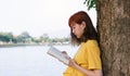 Young girl holding a book for read outdoor in nature background Royalty Free Stock Photo