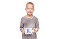 Young girl holding a card with letter K. Speech therapy concept on white background. Correct pronounciation and articulation. Royalty Free Stock Photo