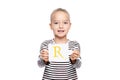 Young girl holding a card with letter R. Speech therapy concept on white background. Correct pronounciation and articulation. Royalty Free Stock Photo