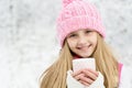 A young girl holding a cup of hot drink and smiling Royalty Free Stock Photo