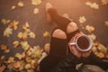 A young girl holding a cup of hot drink and smiling at the background of a autumn forest. Attractive young woman in Royalty Free Stock Photo