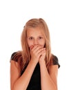 Young girl holding hands over mouth. Royalty Free Stock Photo